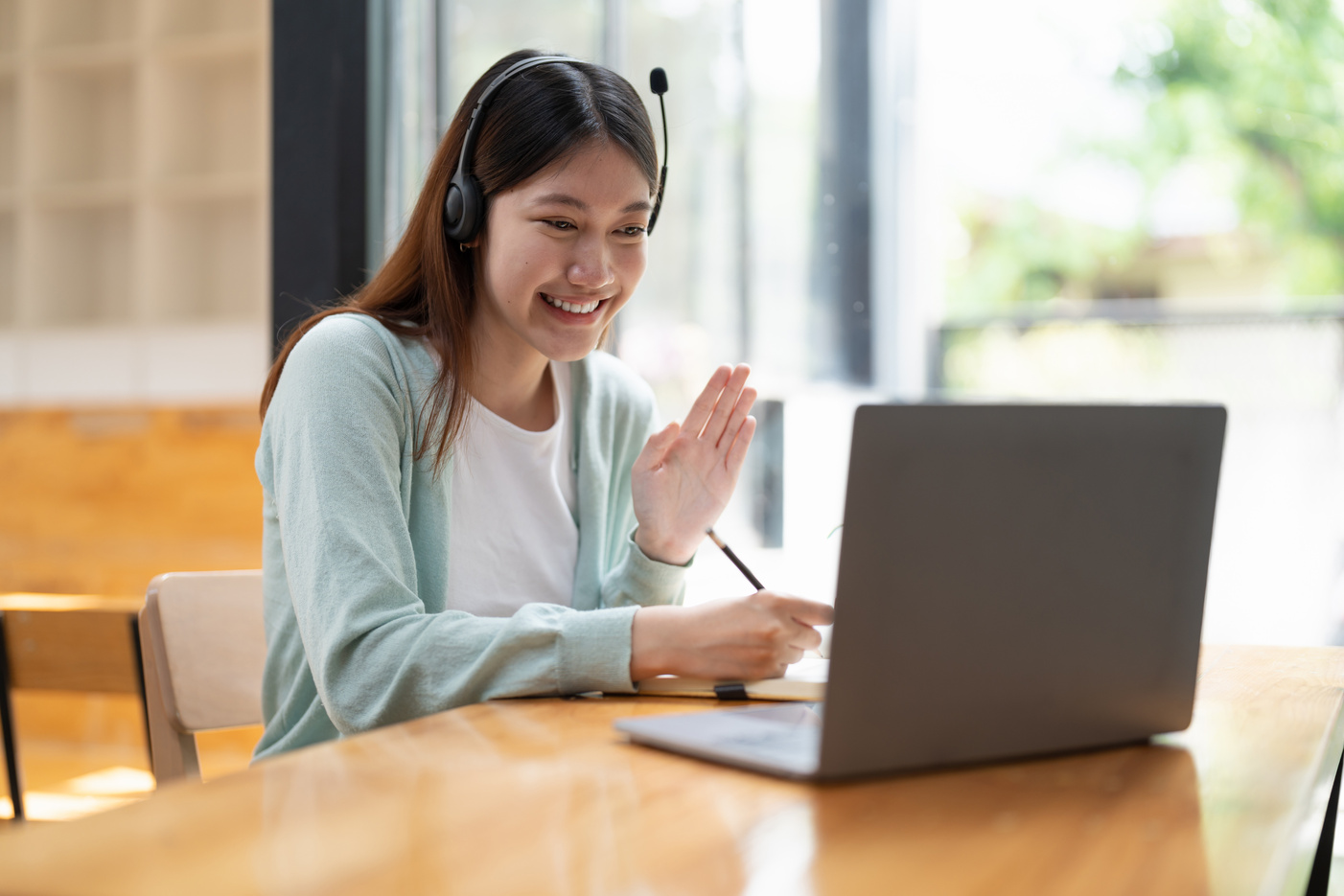 Smiling girl student wear wireless headphone study online wi